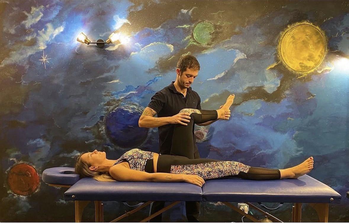Alexandru working hands-on with a client on the treatment table